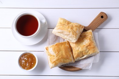 Photo of Delicious puff pastry served on white wooden table, flat lay