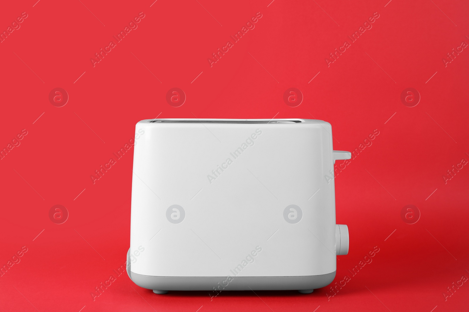 Photo of Modern toaster on red background. Household equipment