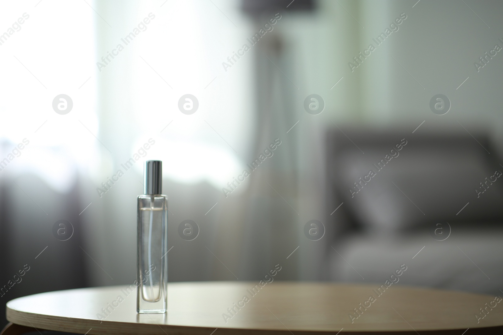 Photo of Aromatic air freshener spray on table indoors. Space for text