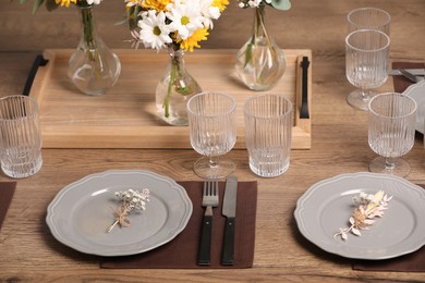 Photo of Elegant festive setting with floral decor on wooden table