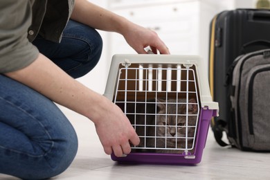 Travel with pet. Man closing carrier with cat indoors, closeup