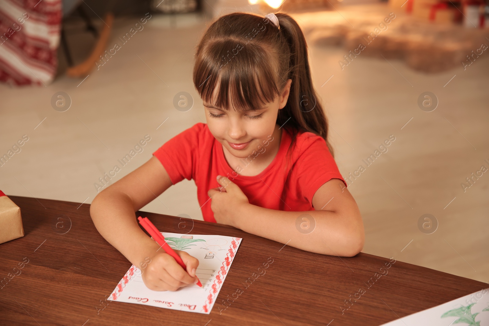 Photo of Little child writing letter to Santa at home. Christmas celebration