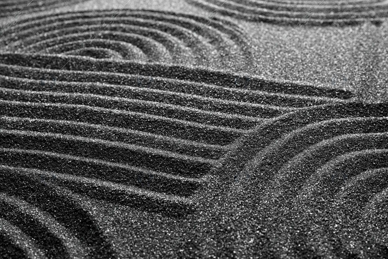 Photo of Pattern on decorative black sand, closeup. Zen and harmony