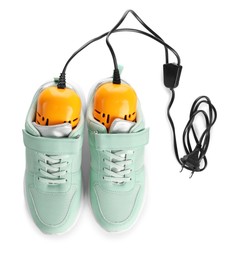 Photo of Pair of stylish sneakers with modern electric shoe dryer on white background, top view