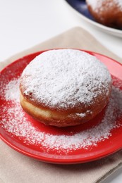 Delicious sweet bun with powdered sugar on table, closeup