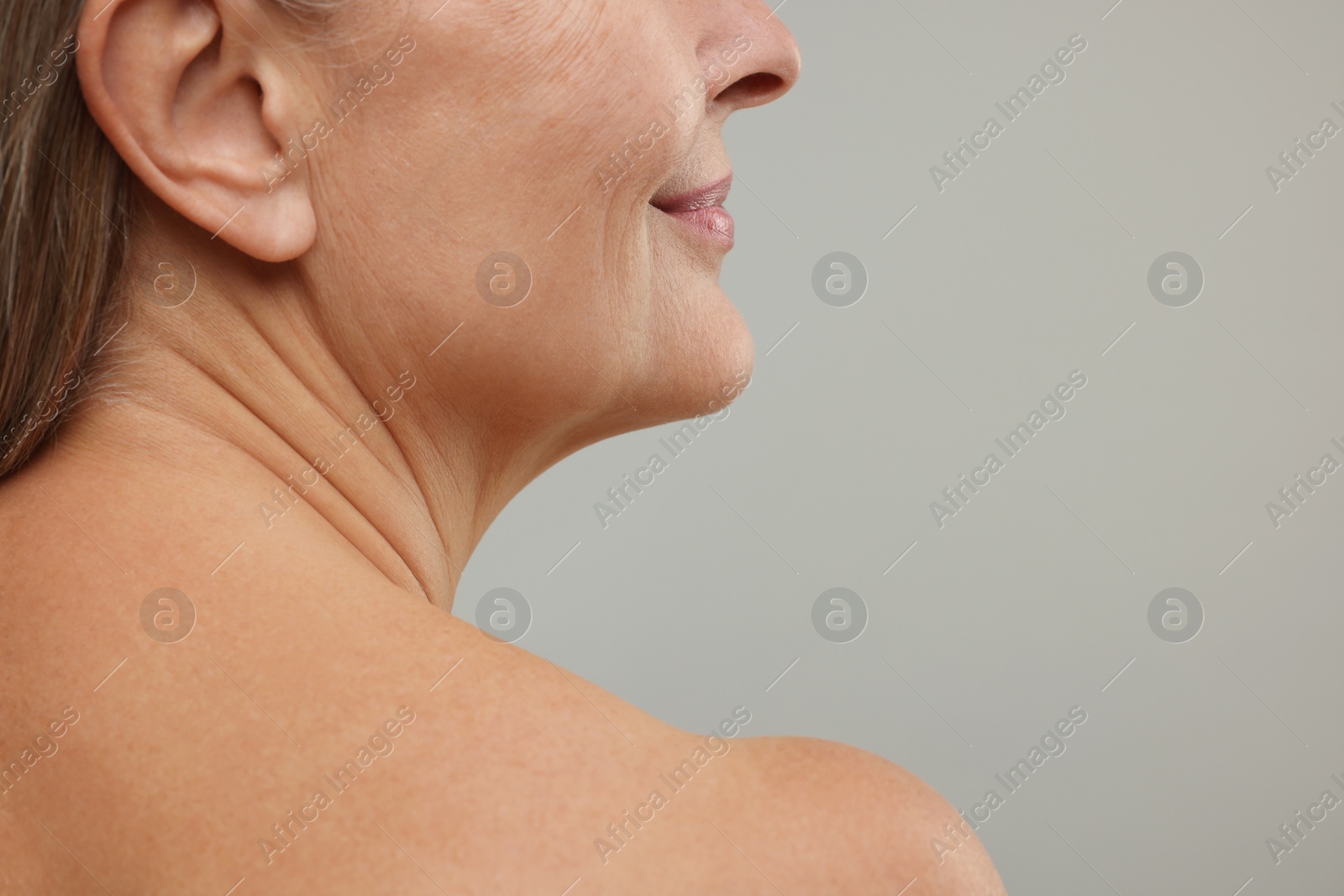 Photo of Mature woman with healthy skin on grey background, closeup. Space for text