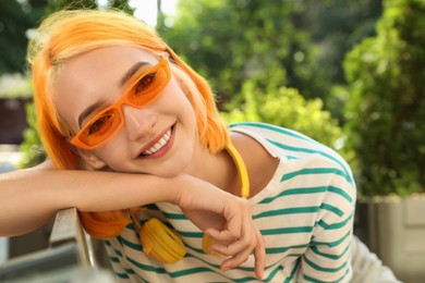 Photo of Beautiful young woman with bright dyed hair in park
