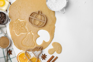 Photo of Flat lay composition with cookie cutters and dough on white table. Space for text