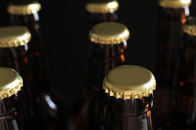 Photo of Many bottles of beer on dark background, closeup view