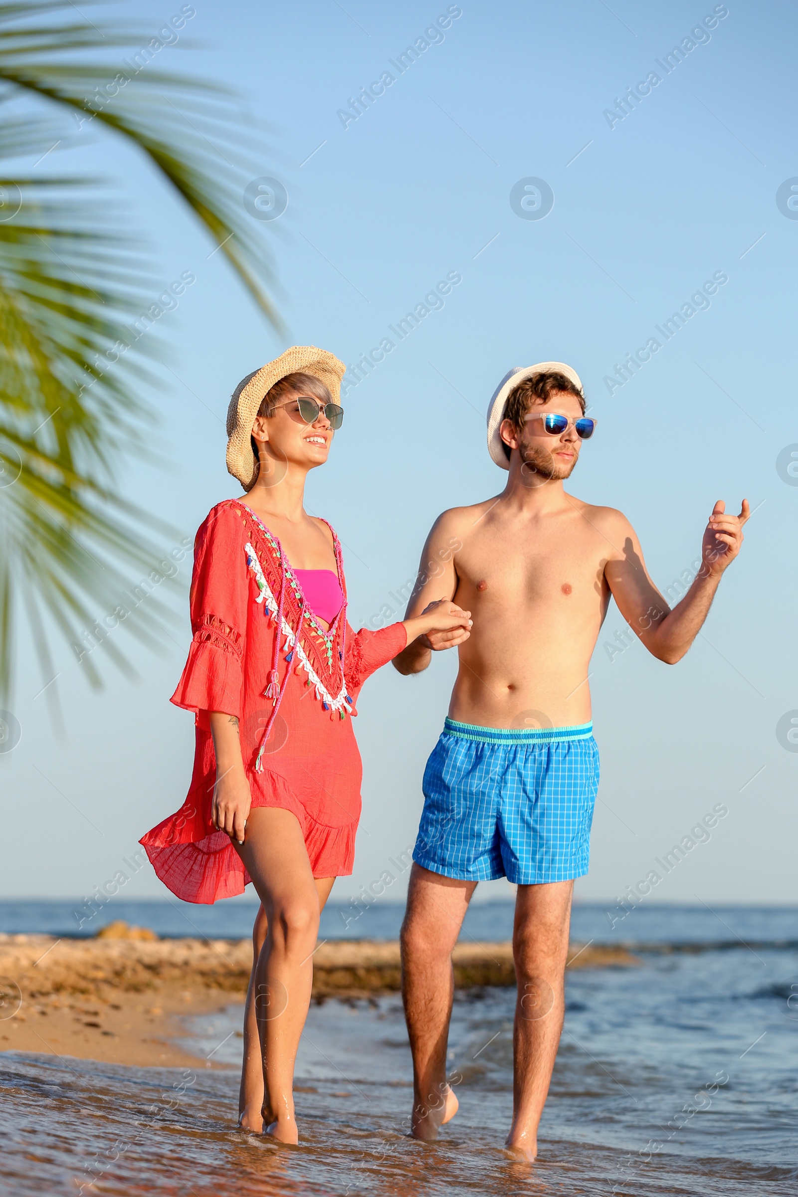 Photo of Happy young couple walking together on beach
