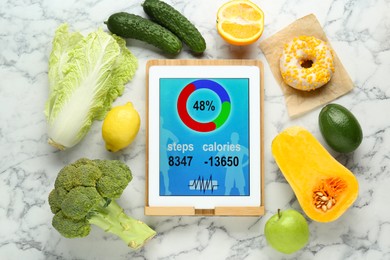 Photo of Tablet with weight loss calculator application and food products on white marble table, flat lay