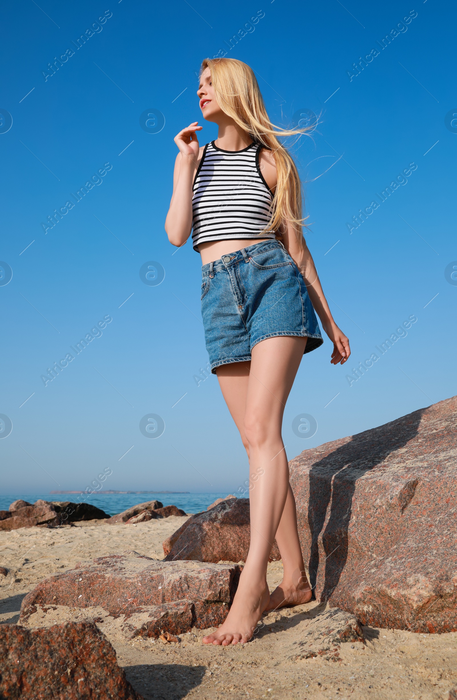 Photo of Beautiful young woman near sea on sunny day in summer