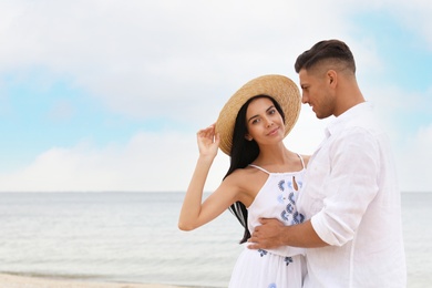 Photo of Lovely couple spending time together on beach. Space for text