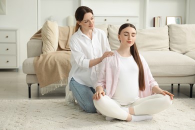 Photo of Doula taking care of pregnant woman at home. Preparation for child birth