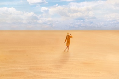 Image of Woman walking in desert on sunny day