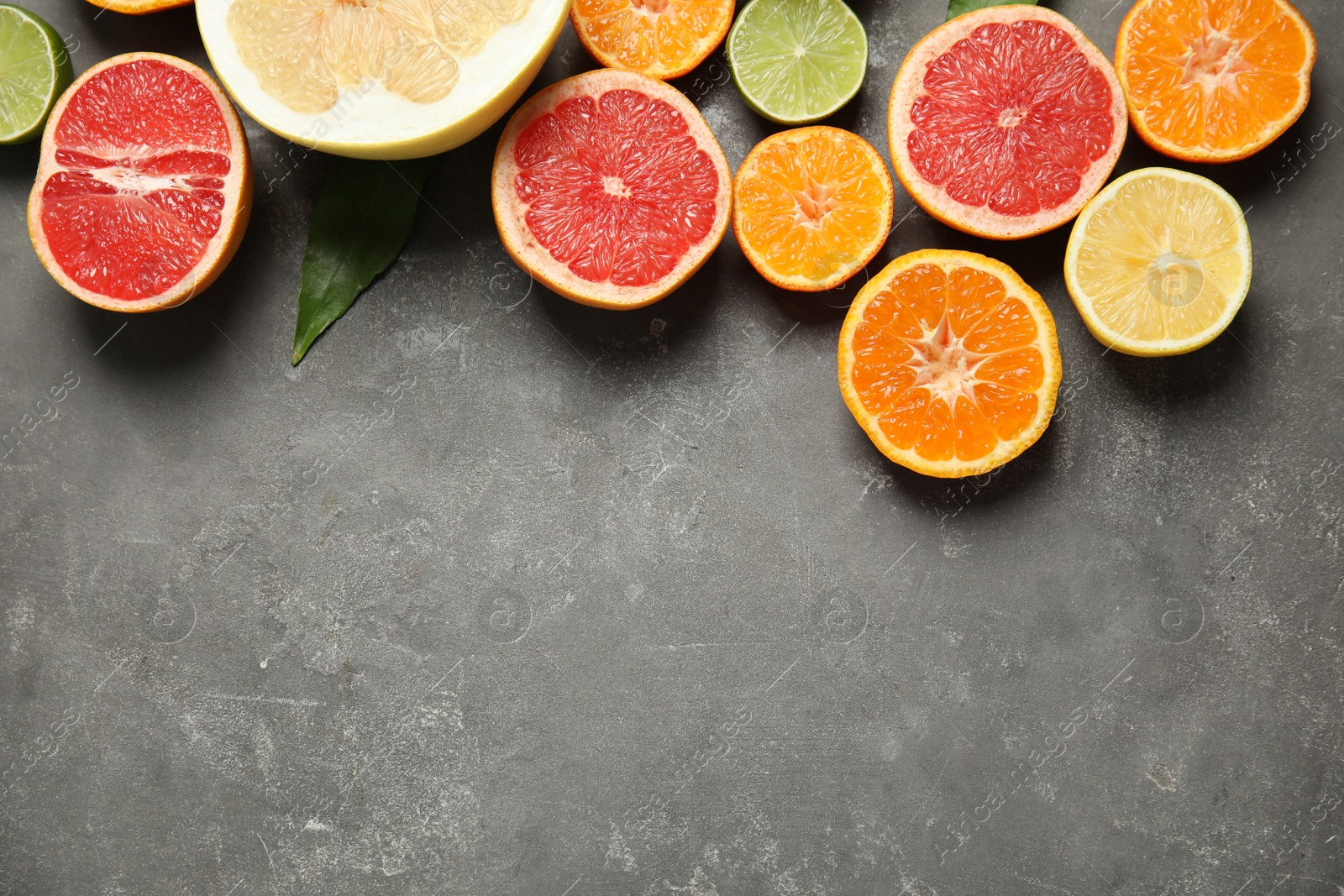 Photo of Different citrus fruits on grey background, top view. Space for text