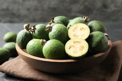 Photo of Plate with delicious fresh feijoas on table, closeup