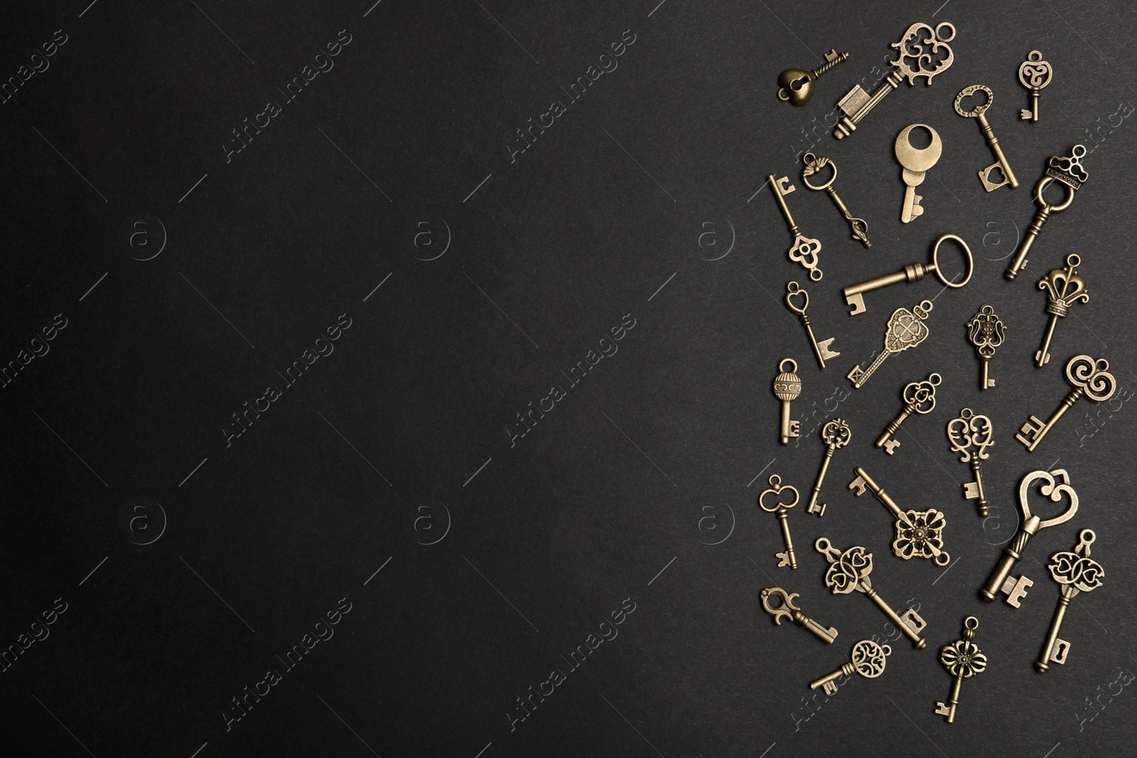 Photo of Flat lay composition with bronze vintage ornate keys on dark background, space for text