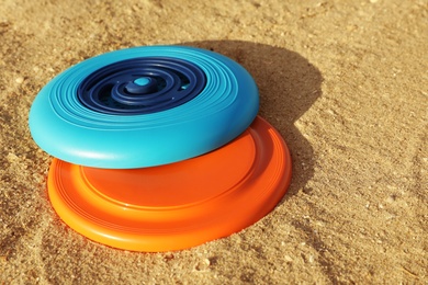 New plastic frisbee discs on sandy beach