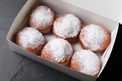 Delicious sweet buns in box on dark gray table, above view