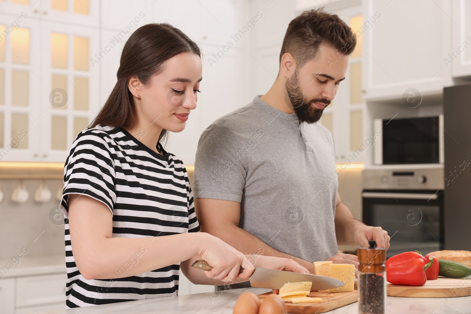 Photo of Lovely young couple cooking together in kitchen