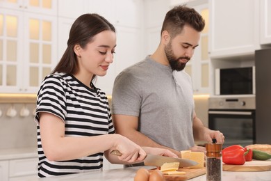 Lovely young couple cooking together in kitchen