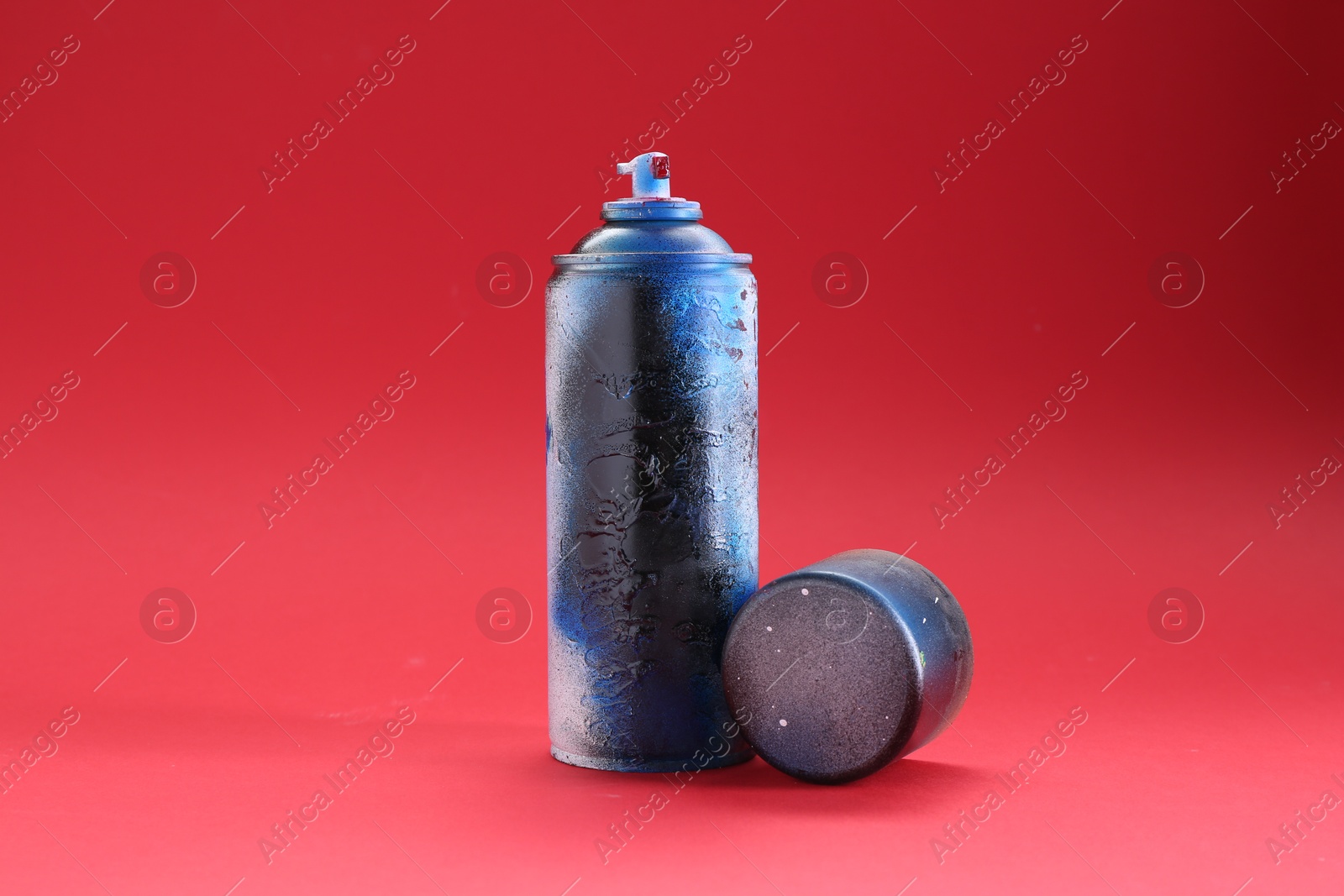 Photo of One can of bright spray paint with cap on red background