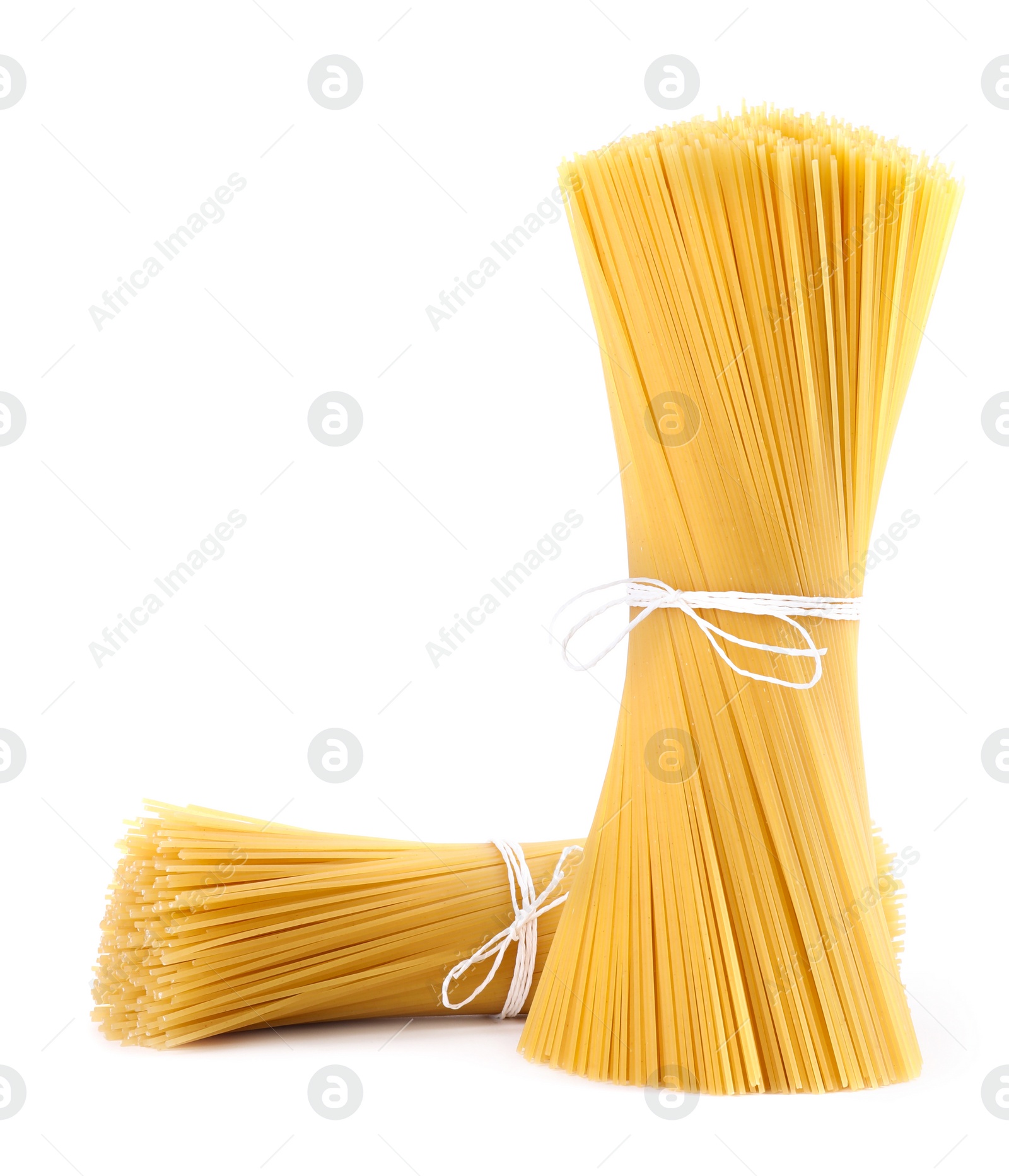 Photo of Tied uncooked Italian spaghetti isolated on white