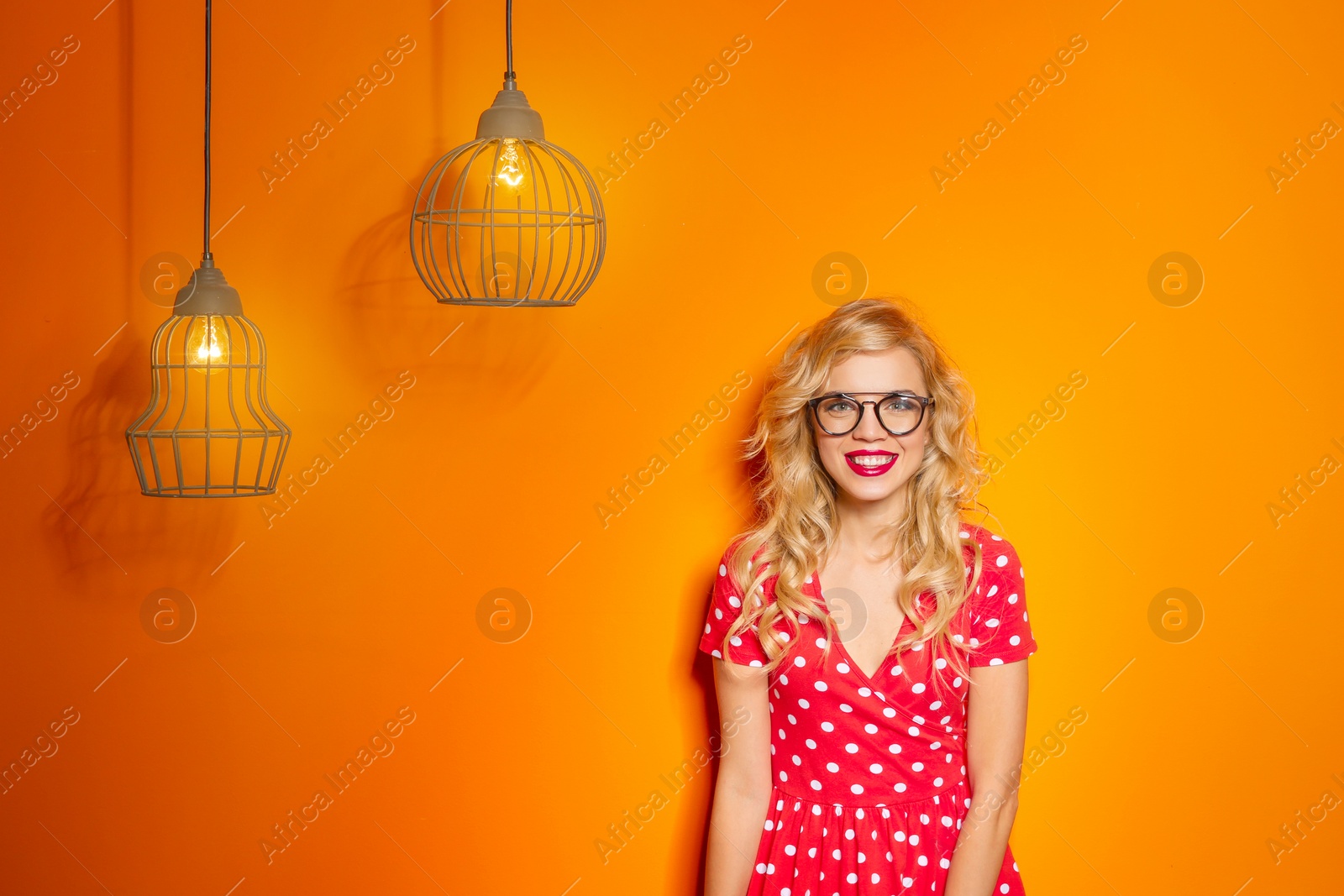 Photo of Stylish young woman with glasses posing on color background