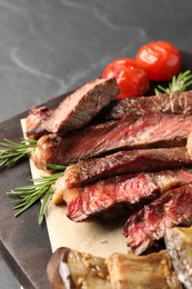 Delicious grilled beef with vegetables and rosemary on dark gray table, closeup