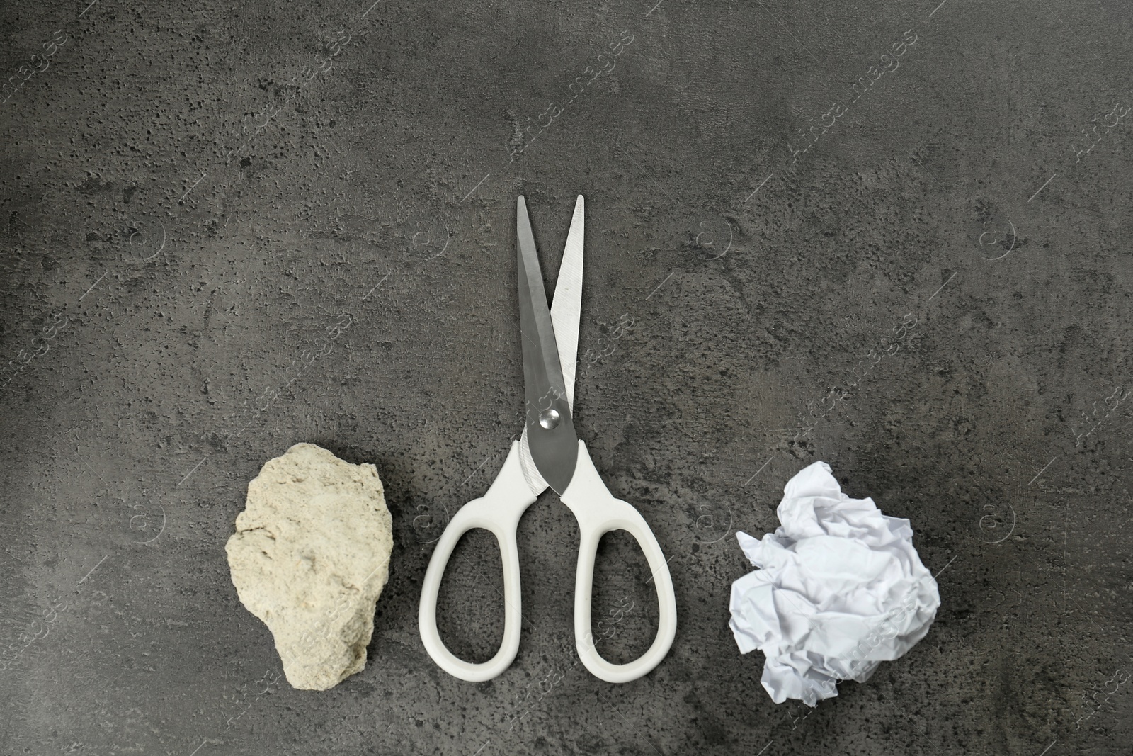 Photo of Flat lay composition with rock, paper and scissors on grey stone background