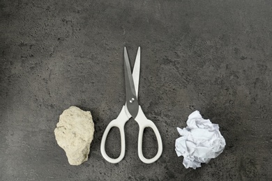 Photo of Flat lay composition with rock, paper and scissors on grey stone background