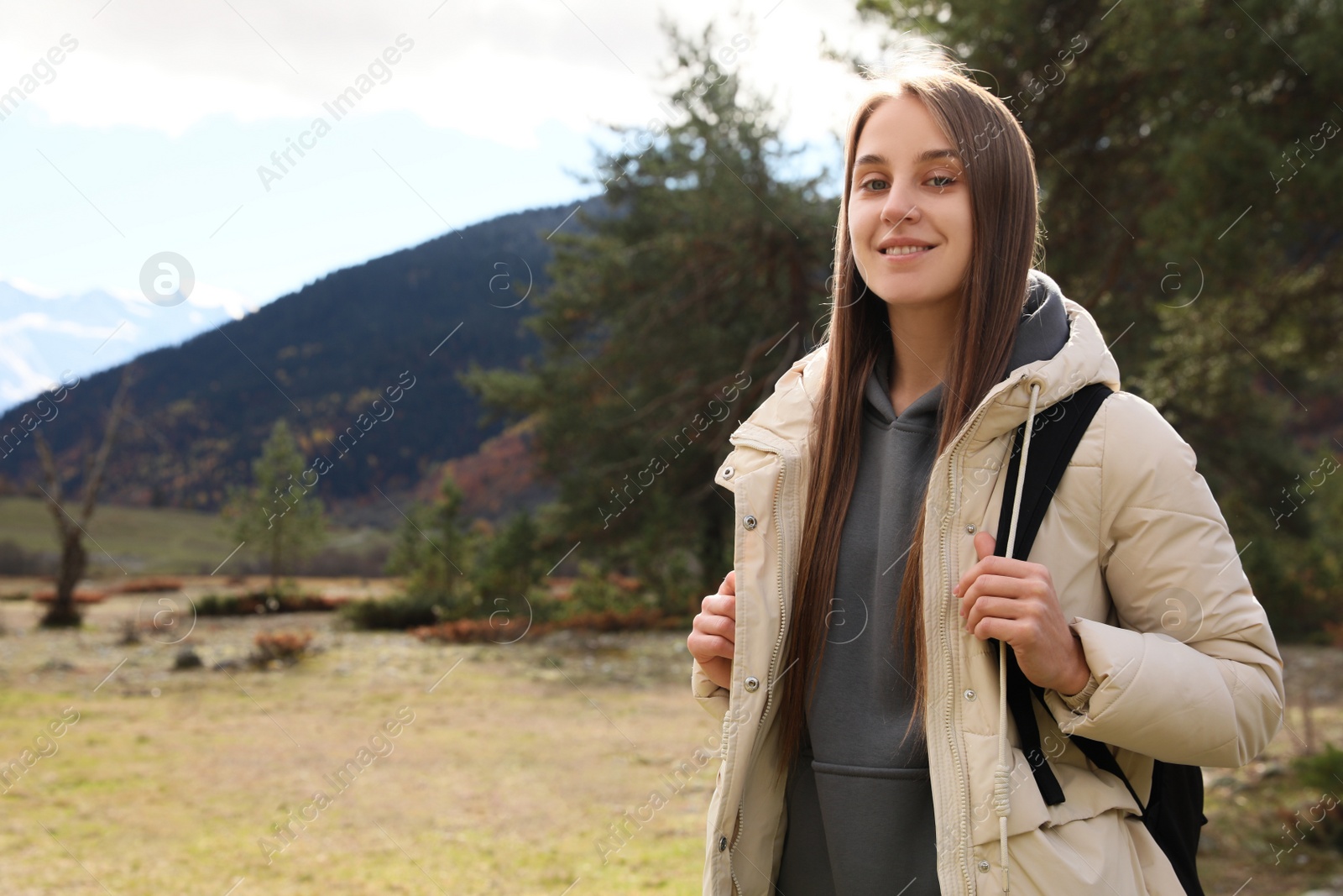 Photo of Happy woman with backpack in beautiful mountains. Space for text