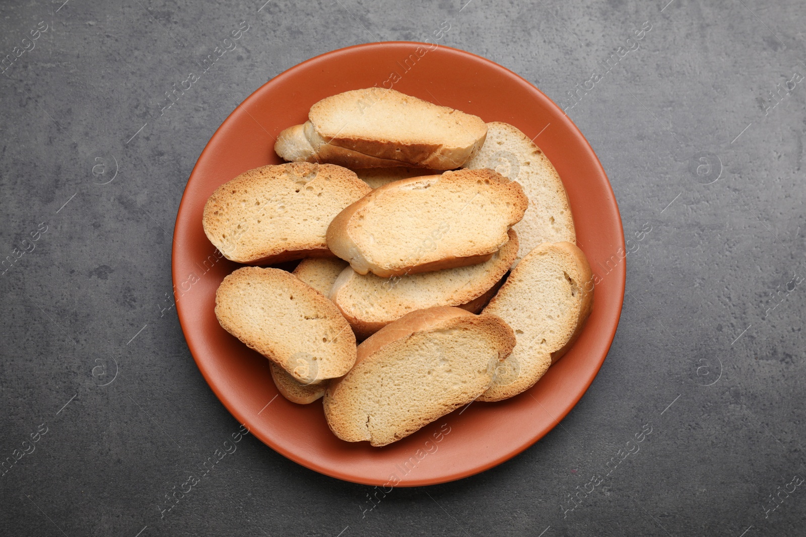 Photo of Plate of hard chuck crackers on grey table, top view