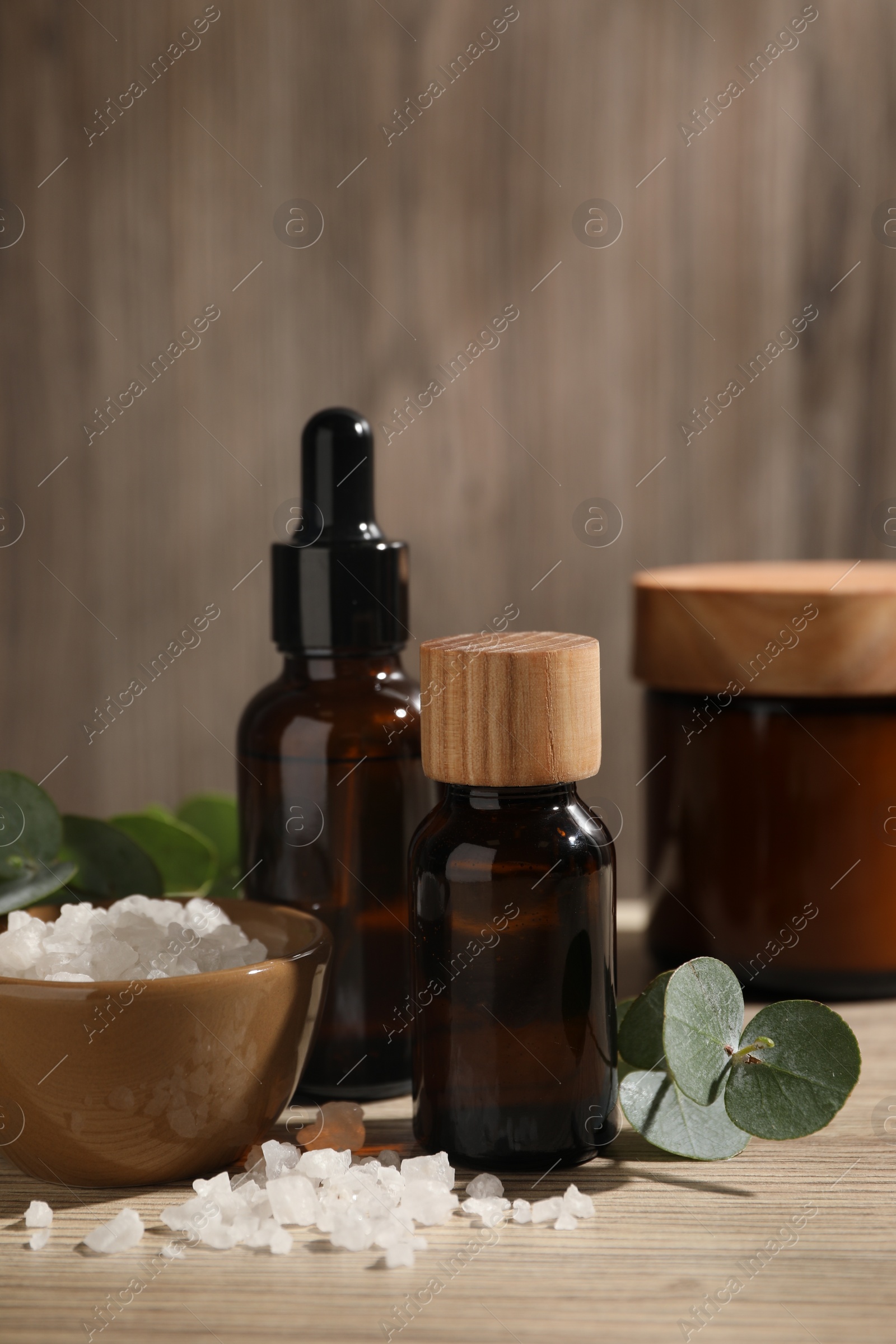 Photo of Composition with spa products and eucalyptus leaves on wooden table