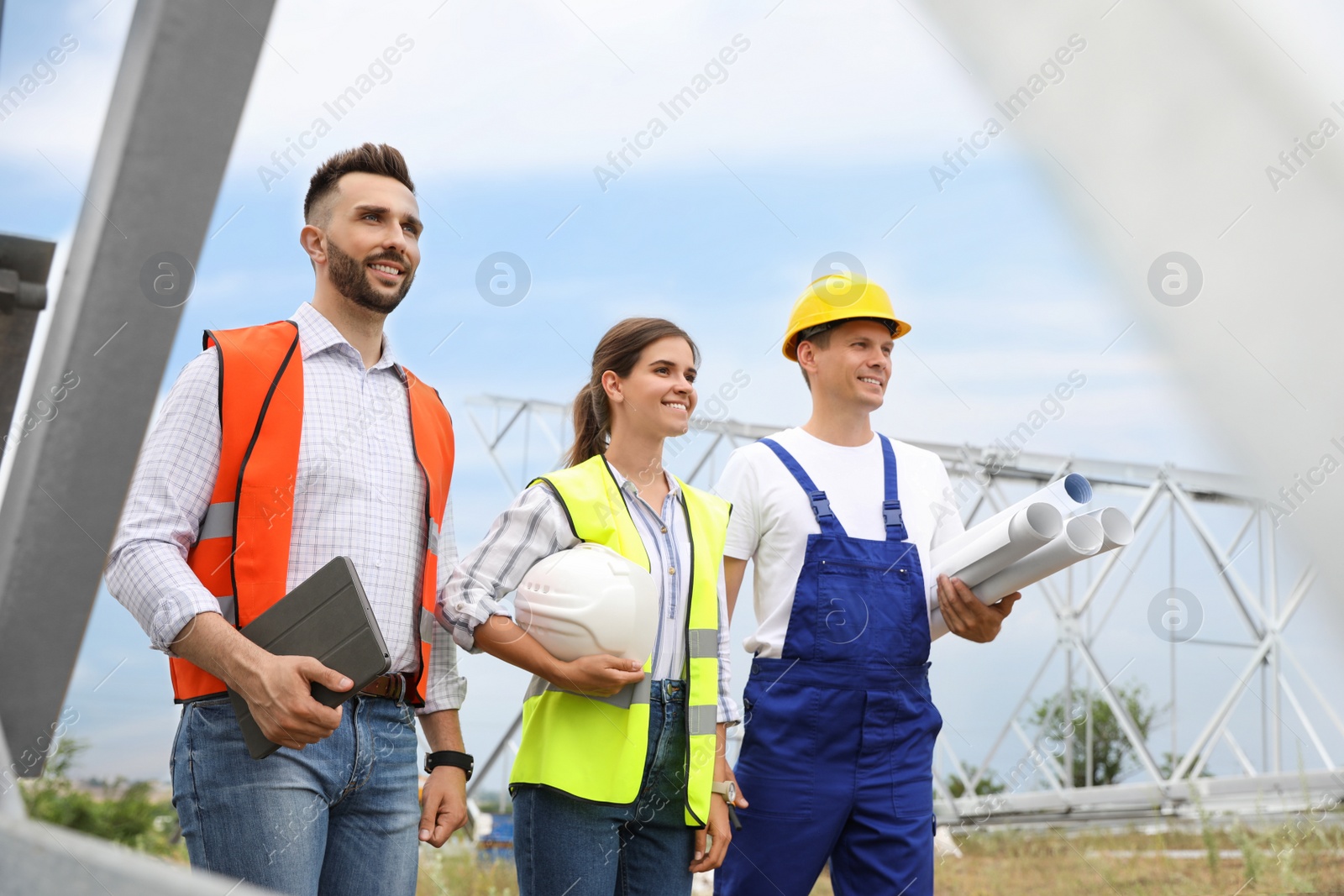 Photo of Professional engineers working on installation of electrical substation outdoors