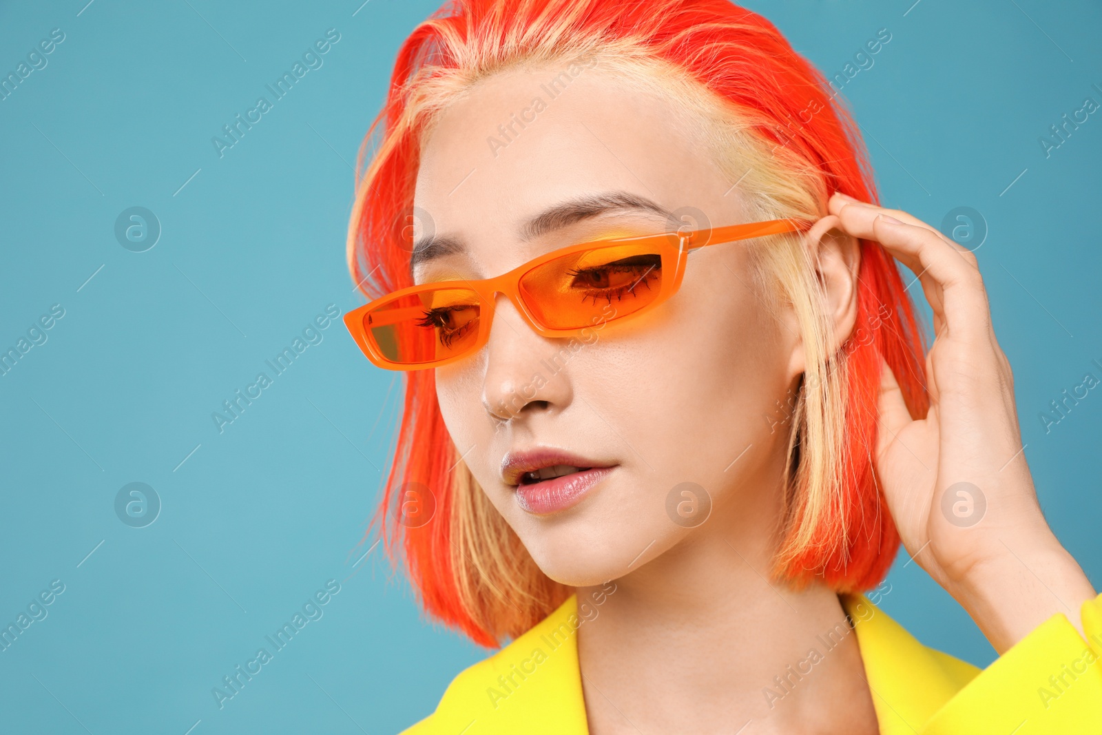 Photo of Beautiful young woman with bright dyed hair on turquoise background, closeup