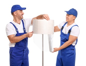 Workers wrapping lamp in stretch film on white background