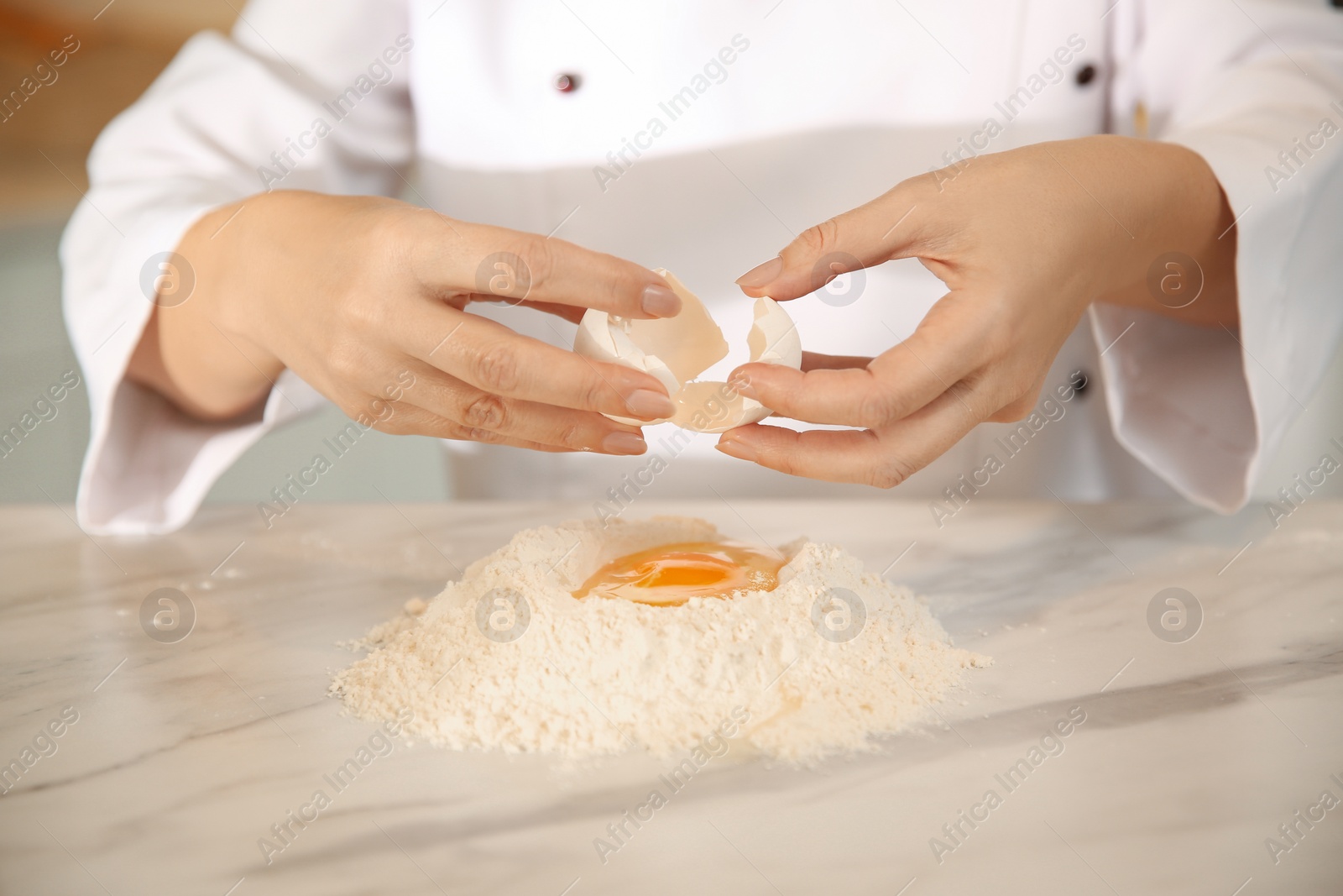 Photo of Chef cooking dough at table in kitchen, closeup