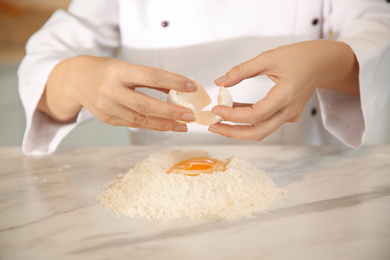 Chef cooking dough at table in kitchen, closeup