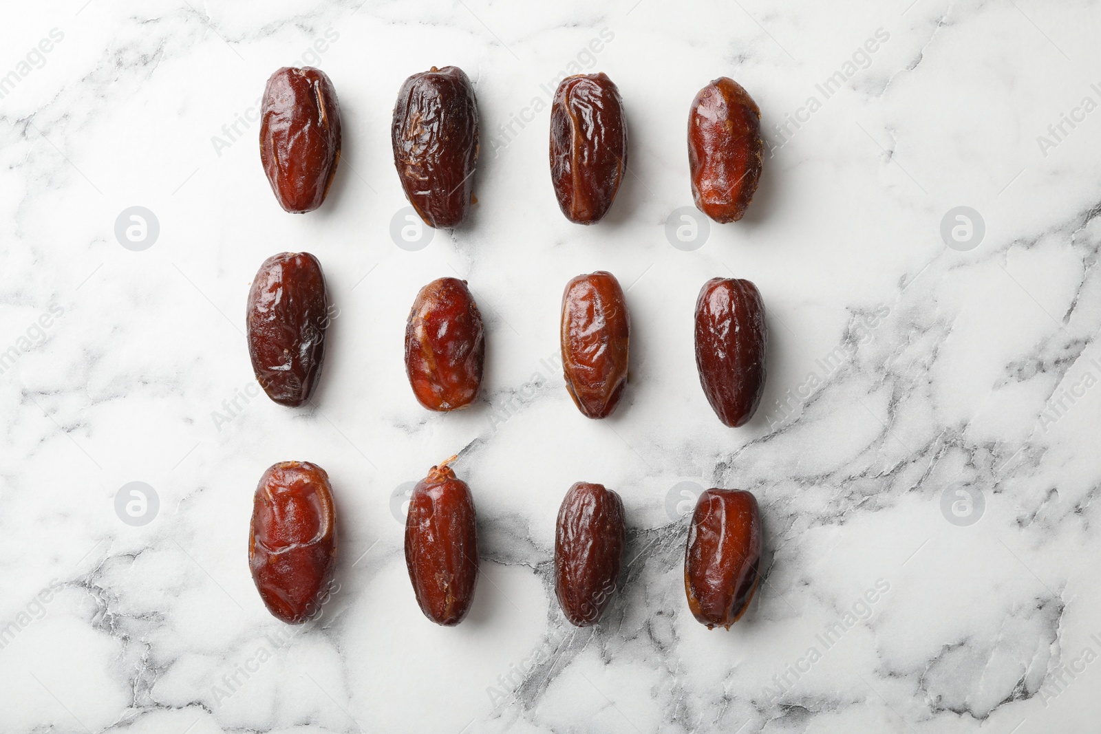 Photo of Flat lay composition with dates on marble background. Dried fruit as healthy snack