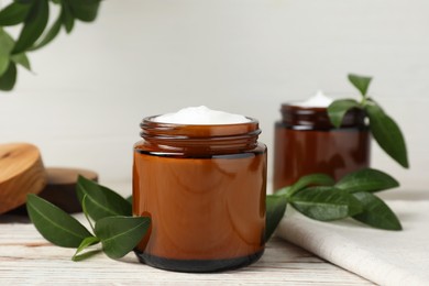 Jar of face cream on white wooden table