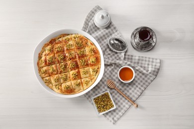 Delicious sweet baklava served on white wooden table, flat lay