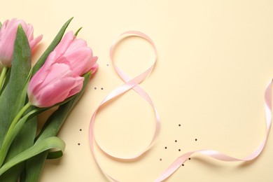 Photo of 8th of March greeting card design with pink ribbon, beautiful flowers and space for text on beige background, flat lay. International Women's day