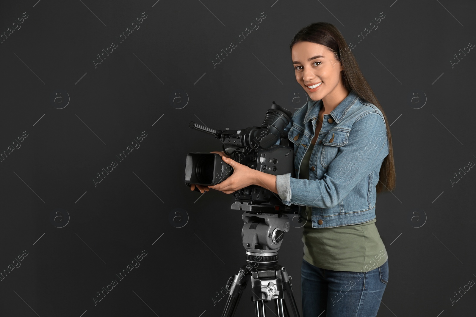 Photo of Operator with professional video camera on black background