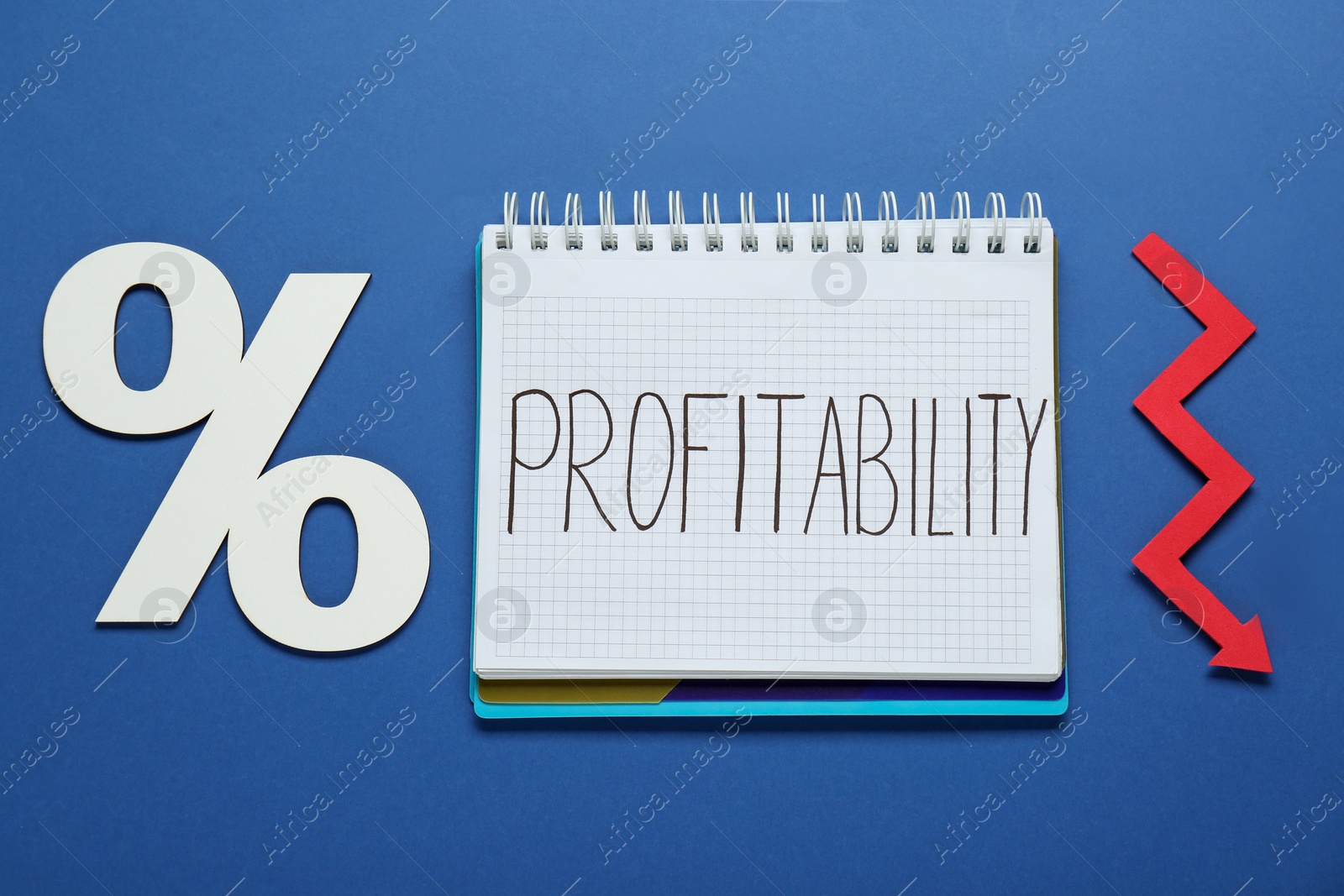 Photo of Notebook with word Profit, percent symbol and up arrow on blue background, flat lay