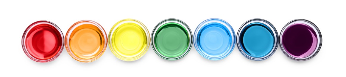 Glass bowls with different food coloring on white background, top view