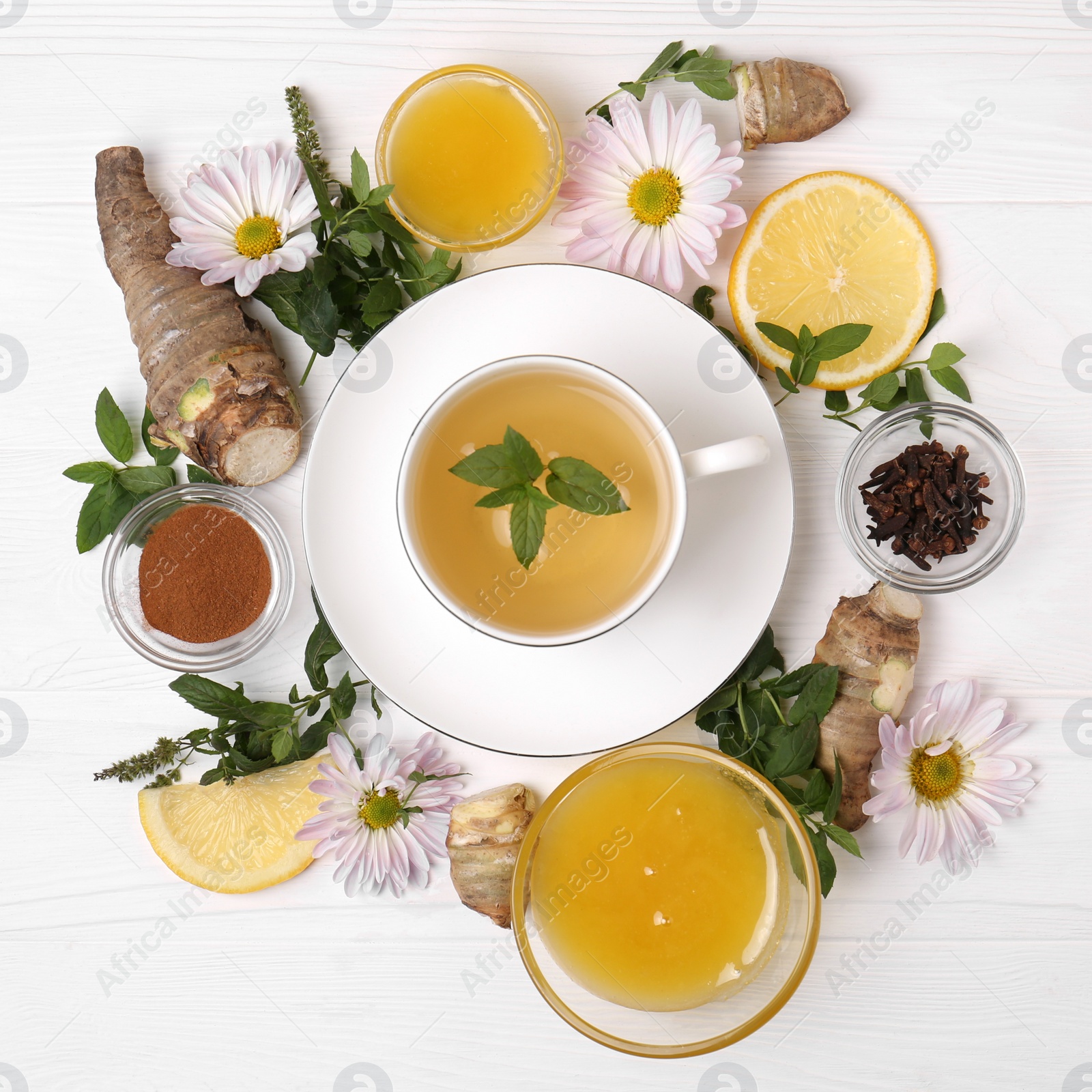 Photo of Flat lay composition with cup of delicious tea, honey and ginger on white wooden table