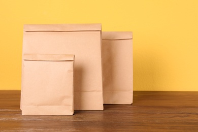 Paper bags on table against color background. Mockup for design