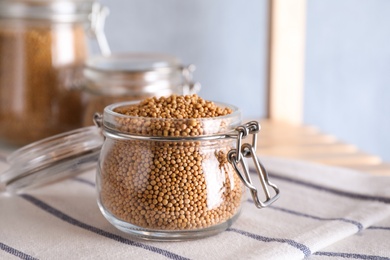 Mustard seeds in glass jar on table